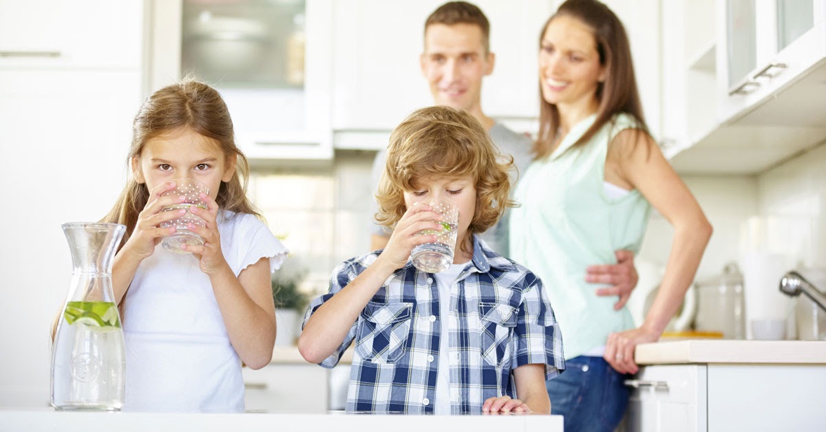 Famiglia felice con bambini, beve acqua pura osmotizzata